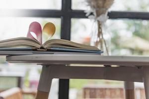 open book and heart shape copy space concept of love Festive background with bokeh and sunlight photo