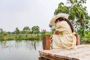 side view of the girl alone on the bridge The child is unhappy, feels pressured, thinks about the child's problems. The concept of depression in adolescence. photo