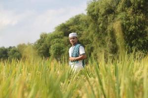 joven musulmán asiático en el campo de arroz foto