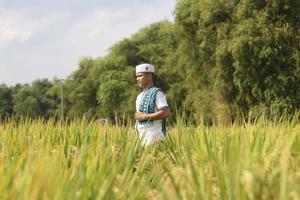 joven musulmán asiático en el campo de arroz foto