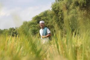 joven musulmán asiático en el campo de arroz foto