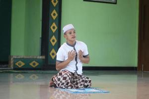 joven musulmán asiático rezando en la mezquita foto