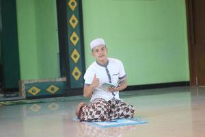 Young asian muslim praying in the mosque photo