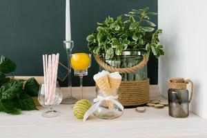 Waffle cone with white ice cream in a glass vase on the kitchen table or in a cafe, selective focus. photo