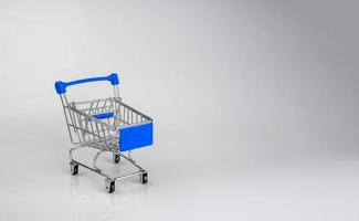 carrito de compras sobre fondo blanco con luces y sombras. concepto de compras. foto