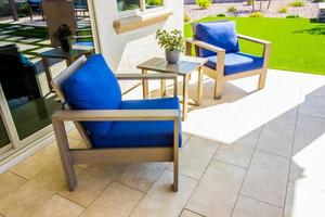 Two Wooden Arm Chairs And Small Table On Rear Yard Patio photo