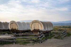 Covered wagons in yard at ranch in Yellowstone park with sky in background photo