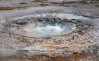 Boiling water in hotspring amidst geothermal landscape at Yellowstone park photo