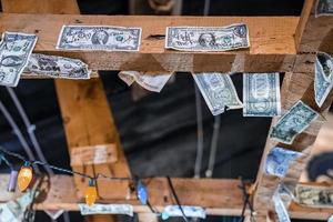 Paper currencies with signatures on wooden ceiling of restaurant photo