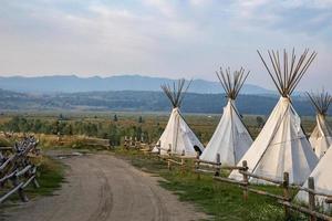 Dirtroad en medio de tipis en campo con cielo nublado de fondo en Yellowstone foto