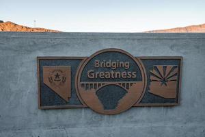 Bronze Plaque With Bridging Greatness Text On Wall photo