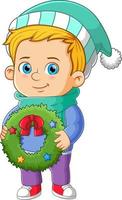 The cute boy is preparing for putting the christmas wreath on the door vector