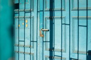 Old wooden door with a shadow pattern on its surface, outdoors. photo