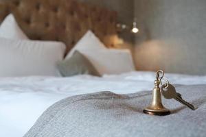 la llave con un llavero de la habitación del hotel se encuentra en la cama. foto