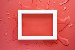 White rectangular empty frame on clean spilled water, on a pink background. Copy space. Top view. photo