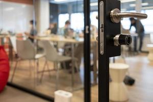 Open door to a coworking space, blurred silhouettes of people during a hackathon photo