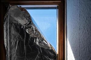 Window covered with foil to prevent sunlight from entering house during heat photo