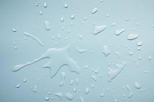 Spilled water on a gray surface, in the form of beautiful splashes. Abstract background. Top view. photo