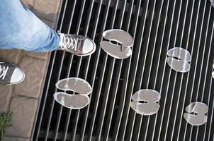 man legs on mesh bridge with metal footprints on a walkway in a petting zoo photo