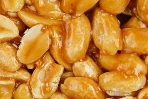 Kozinaki from golden, roasted peanuts beans as a background, texture. Macro shooting, close-up. Place for text photo