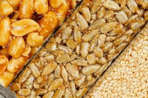 Assorted kozinaki, sweets from sunflower seeds, sesame and peanuts filled with brilliant glaze. Macro photo