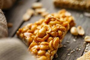 Assorted kozinaki, on old vintage background, with burlap fabric. Country style. Delicious sweets from the seeds of sunflower, sesame and peanuts, covered with shiny glaze. photo