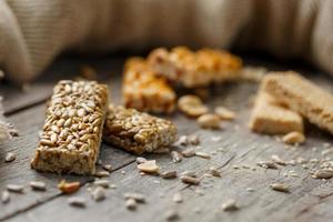 Assorted kozinaki, on old vintage background, with burlap fabric. Country style. Delicious sweets from the seeds of sunflower, sesame and peanuts, covered with shiny glaze. photo