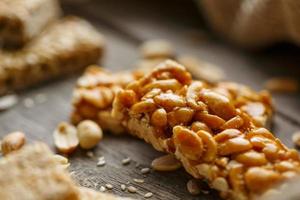 Assorted kozinaki, on old vintage background, with burlap fabric. Country style. Delicious sweets from the seeds of sunflower, sesame and peanuts, covered with shiny glaze. photo