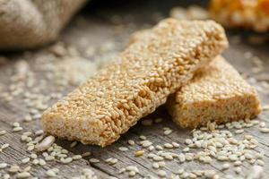 Sesame seed casinos on old vintage background with burlap cloth. Country style. Delicious sweets from seeds of sunflower, sesame and peanuts, covered with shiny glaze photo