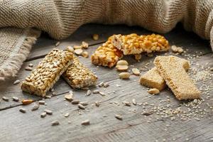 Assorted kozinaki, on old vintage background, with burlap fabric. Country style. Delicious sweets from the seeds of sunflower, sesame and peanuts, covered with shiny glaze. photo