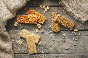 Assorted kozinaki, on old vintage background, with burlap fabric. Country style. Delicious sweets from the seeds of sunflower, sesame and peanuts, covered with shiny glaze. photo