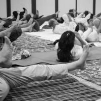 delhi, india, 19 de junio 2022: sesión de ejercicios de yoga en grupo para personas de diferentes grupos de edad en el templo balaji, vivek vihar, día internacional del yoga, gran grupo de adultos que asisten a clases de yoga en blanco y negro foto
