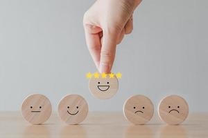 Hand choosing happy smiling face and 5 star crown. Emotion, Think positive, World mental health day, Mental health assessment, Customer experience and service review, Satisfaction, Feedback rating. photo