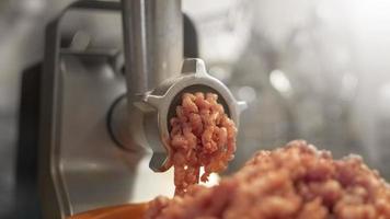 Meat grinder mincing fresh raw meat. Selective focus on an automatic electric meat mincer at home. photo