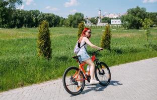 Young woman in the city rides bike and leads an active lifestyle doing sports photo