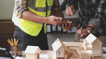 bouw ingenieur werken Bij blauwdruk naar bouwen groot reclame gebouwen in kantoor. bouwkunde gereedschap en bouw concept. video