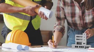 ingénieur en construction travaillant au plan directeur pour construire de grands bâtiments commerciaux au bureau. outils d'ingénierie et concept de construction. video