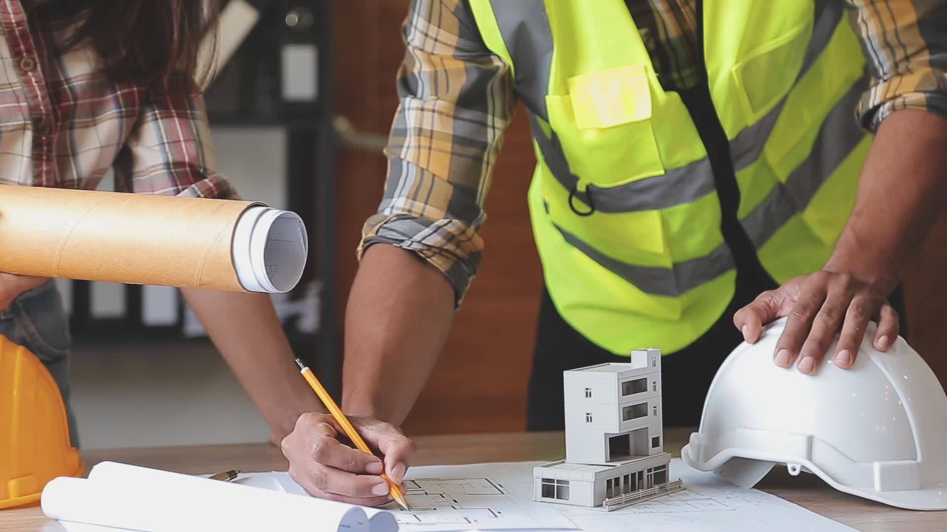 Construction engineer working at blueprint to build large commercial