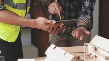 bouw ingenieur werken Bij blauwdruk naar bouwen groot reclame gebouwen in kantoor. bouwkunde gereedschap en bouw concept. video