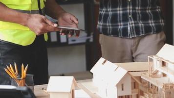 ingénieur en construction travaillant au plan directeur pour construire de grands bâtiments commerciaux au bureau. outils d'ingénierie et concept de construction. video