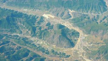 belle vue à travers la fenêtre de l'avion, avion volant au-dessus des montagnes. territoire chinois. video