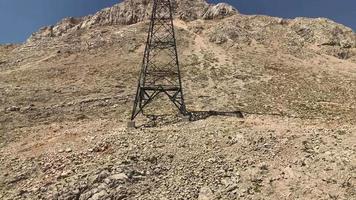 Blick aus dem Inneren der Kabine der Seilbahn, die in die Berge hinauffährt. Wüstenberg und elektrischer Turm. Video in hoher Qualität 4k