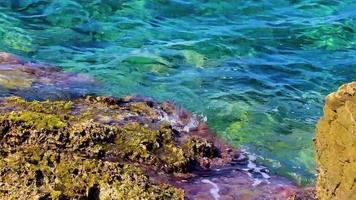 strand en kleurrijk turkoois blauw water structuur voula vouliagmeni Griekenland.