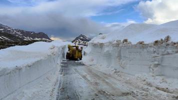 Bobcat machine, skid steer cleaning high snow on the road. Harsh winter. Road closure. Precautions while driving. Rough weather. Mountain roads in National Park Durmitor in Montenegro. video