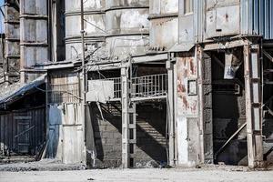 Old destroyed construction site. Rusty scaffolding and construction equipment. photo