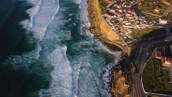 vue aérienne par drone d'azenhas do mar, portugal. piscine naturelle dans l'océan, à côté de la falaise et d'un village balnéaire au coucher du soleil. meilleures destinations du monde. endroits les plus visités. vacances. video
