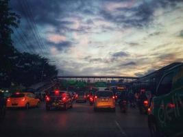 Defocused blurred abstract background of traffic jam at night in east Jakarta. The rear view, the red and yellow lights or the brake lights of the cars are on. photo