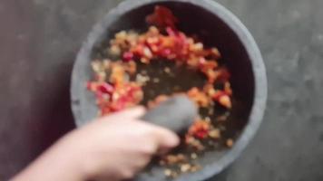 verschwommenes Foto des Prozesses der Herstellung von Urap-Gewürzen. aus Kokosraspeln gemischt mit Chilisauce und Zwiebeln. video