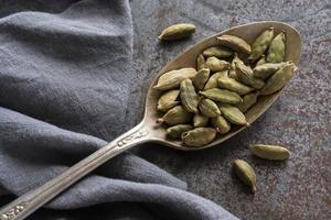 vainas de cardamomo verde en una cuchara vintage foto