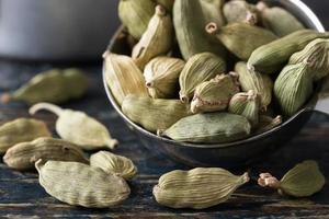 vainas de cardamomo verde derramadas de una cucharadita foto